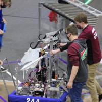 A team takes their robot off the field after a match